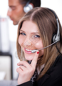 微笑的商业女人通过头电话在客舱里和顾客图片