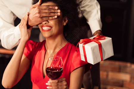 浪漫惊喜面目全非的洲人送情人节礼物给在餐厅庆祝时捂着眼睛的图片