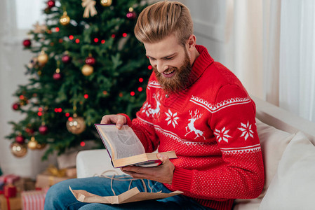英俊的男人把书当作圣诞礼物背景图片