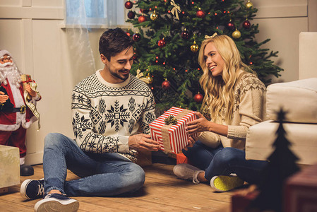 快乐的caucasians女人向男朋友送礼物在圣诞图片