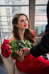 男人在情人节晚宴浪漫约会期间给女友送花束子时的一部份外图片