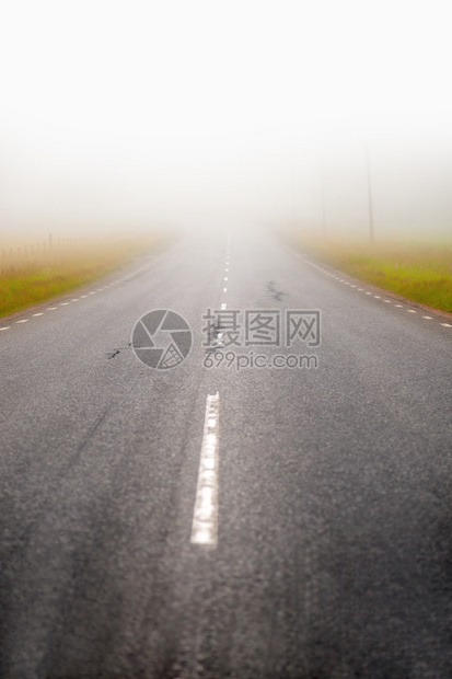 消失在大雾中的农村柏油路图片