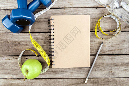 木制桌上的笔记本新鲜苹果测量胶图片