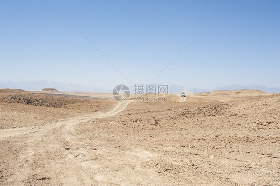 在荒漠的荒漠地貌上乘坐越野车图片