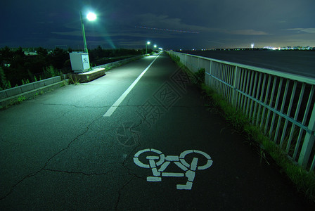 在东京湾堤岸上远行的自行车道的夜景图片