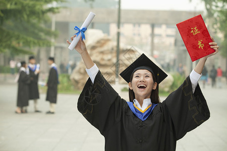 青年女子大学毕业生在空中举载武图片