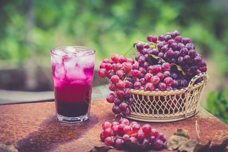 木板上的红葡萄果实和葡萄汁图片
