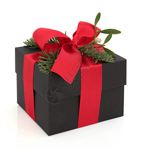 圣诞礼物盒装饰了红色的丝带和弓背景图片