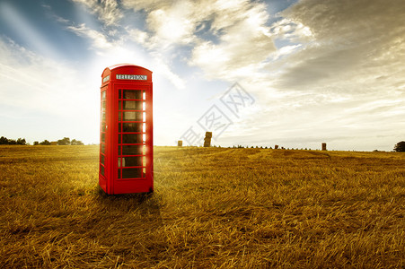 老式传统红色电话亭或公共用电话站在夜光图片