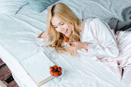 穿着睡衣吃草莓和早上在床上看书的有魅图片