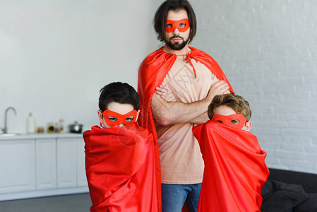 男人和儿子的肖像穿着红色超级英雄服装在图片