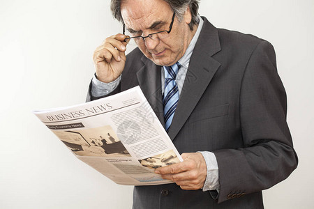 商人在灰色背景下阅读报纸图片