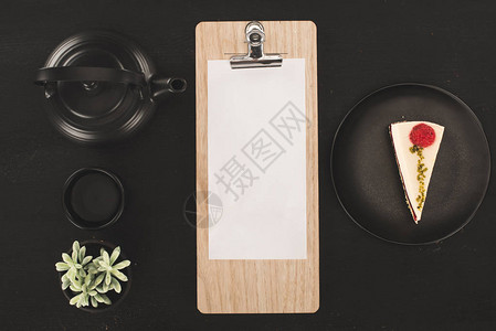 剪贴板上纸页蛋糕和黑茶盒上的图片