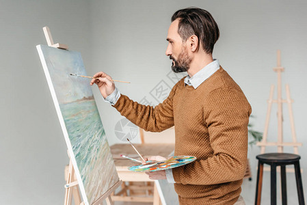 美术课上长胡子的男子画在图片