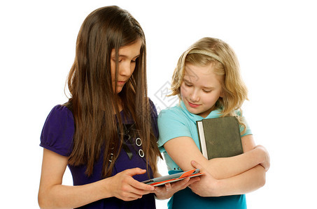 一台女孩使用平板电脑和另一台女孩收藏的书图片