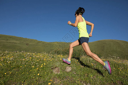 跑草原的年轻健身妇女足迹赛跑者背景图片