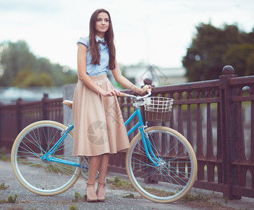 年轻美丽穿着优雅打扮的骑单车女青年背景图片