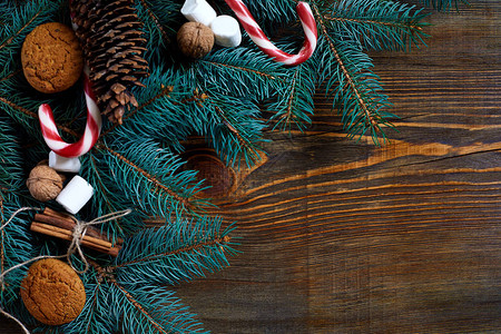 圣诞节或背景与饼干香料肉桂坚果和冷杉树枝在深色木制背景上复制文本桌面视图的空间20背景图片