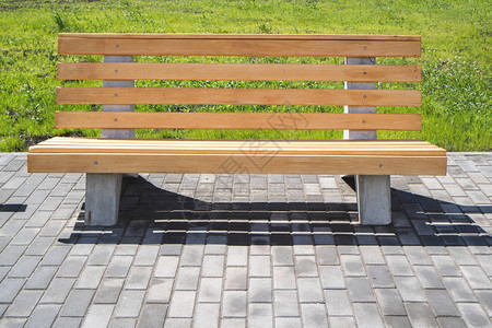 以绿草坪为背景坐在人行道木制板凳图片