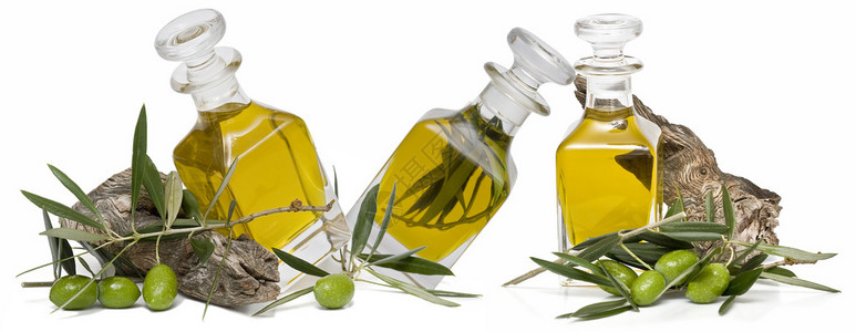 橄榄油瓶和一些有橄榄枝的树枝在图片