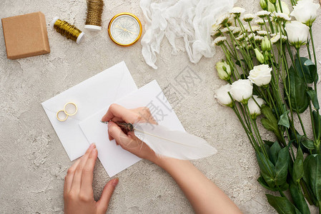 毛笔笔刷妇女写在紧靠结婚戒指罗盘芝衣鲜花和送礼盒表背景