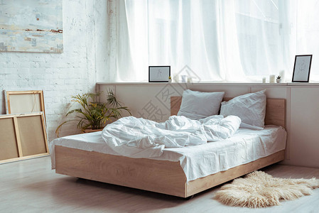 卧室内有舒适的床铺枕头毯子图片