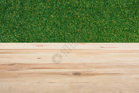 背景为绿草的米色木地板模图片