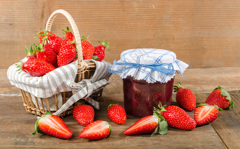 木制背景中带新鲜草莓的果酱罐图片