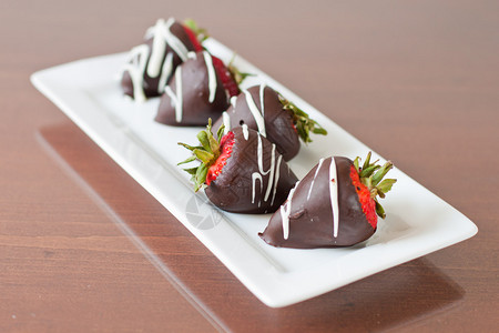 五条巧克力覆盖五行草莓集中在另一条面对的图片