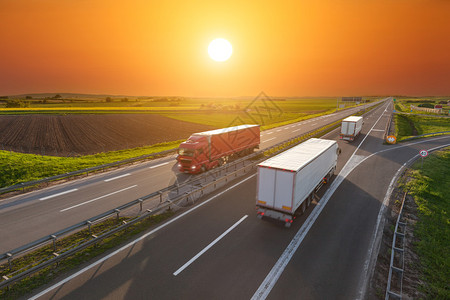 三辆大卡车驶向太阳在美丽的日落高速公路上快速模糊的运动驱器塞尔维亚贝尔格莱德附近高速公路背景图片