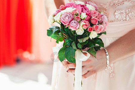 穿着白玫瑰和紫玫瑰的婚纱束图片