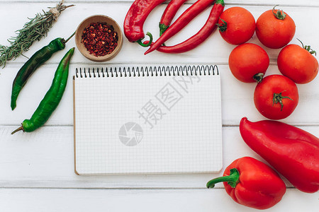 红辣椒西红柿和白木背景的绿辣椒图片