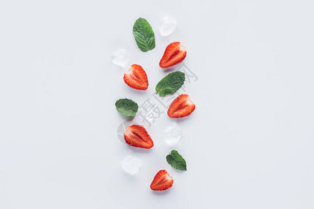 白色表面上有薄荷叶和冰块的草莓减图片
