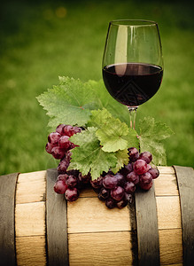一杯红酒和葡萄的绿叶在酒图片