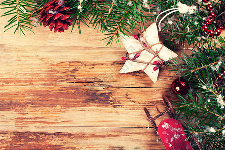 圣诞节背景与圣诞枞树星松果和雪橇在老式风格的旧木板上图片