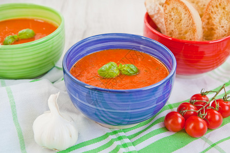 新鲜奶油番茄汤含有机大蒜和青蓝碗图片