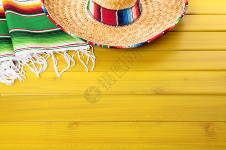 在黄漆的松木林地板上铺设了墨西哥角膜和传统的青蛙毯背景图片
