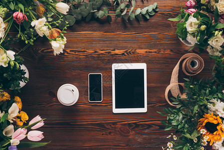 纸杯智能手机和有花的桌子板上的图片