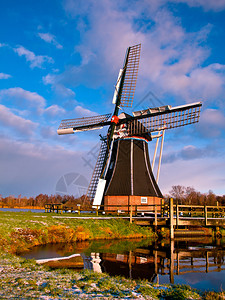 荷兰风车停在湖水边云背景图片