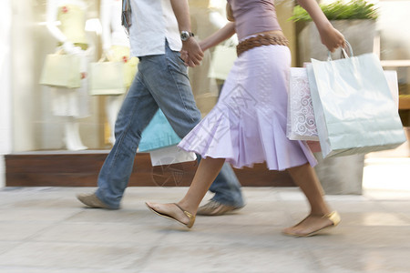 一对夫妇带着购物袋走在购物图片素材