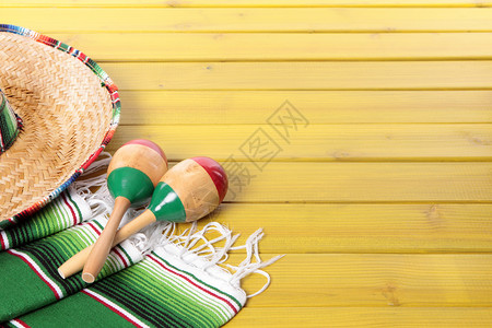 在黄漆松木地板上铺设的墨西哥索布雷罗马拉卡斯和传统的青蛙背景图片