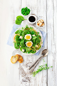 带绿豆菠菜叶和白木背景鸡蛋的新鲜夏沙拉图片