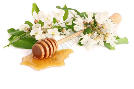 蜂蜜棒与流的蜂蜜和花朵孤背景图片