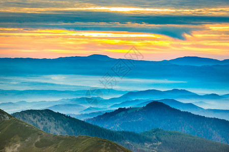 日落时在蓝色山丘上的戏剧彩云图片