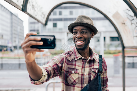 一个年轻英俊的黑人半身手持智能手机图片