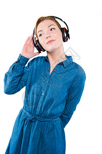 美丽的时髦女孩用耳机监听音乐在背景图片