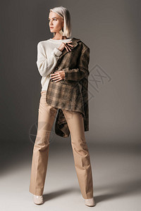 时尚优雅的模特装扮在秋天毛衣米色裤子和西草夹图片