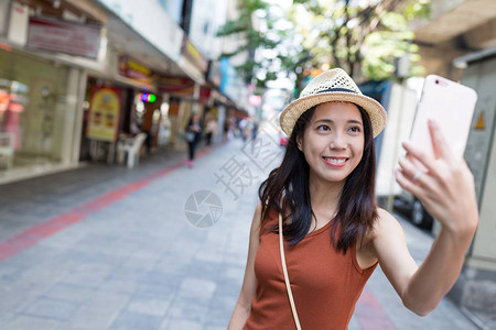 曼谷街头用手机自拍的女人背景图片