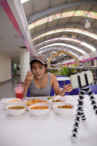 在曼谷市餐厅享受印度美食的年轻亚洲观光女游客肖像图片