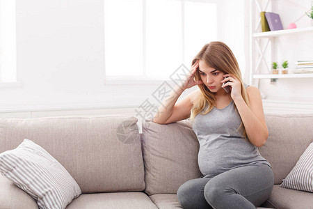 担心的孕妇通电话悲伤的期待金发女郎与她的医生认真交谈医疗保健咨询怀孕问背景图片
